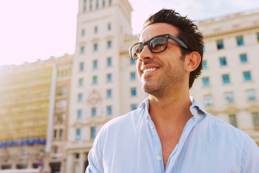 Confident man wearing stylish sunglasses outdoors in a city environment, representing premium eyewear and vision care from Coachella Valley Optometry Indio - Coachella Valley Optometry Indio